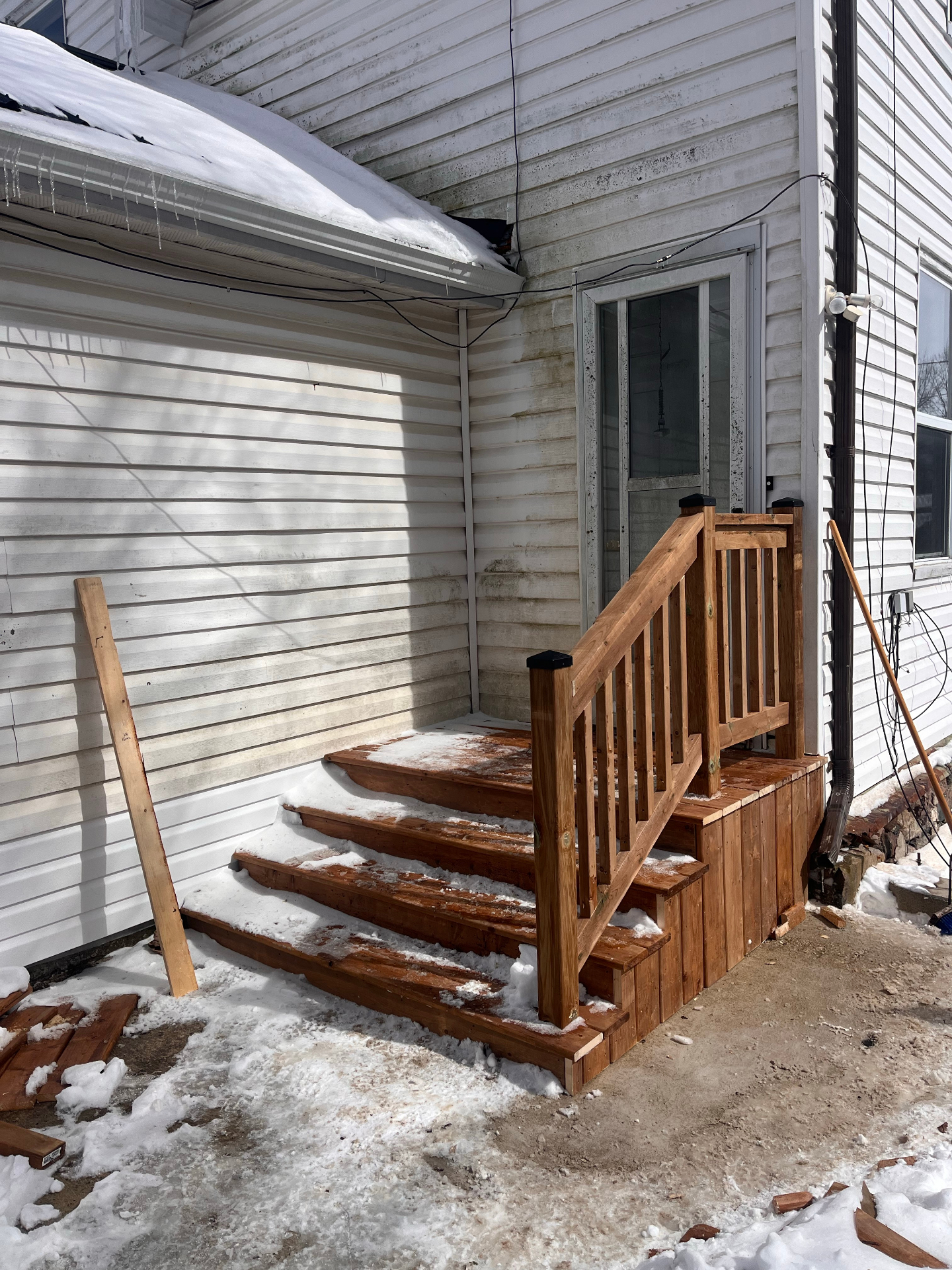 New wood entry steps and refreshed exterior entry area in winter