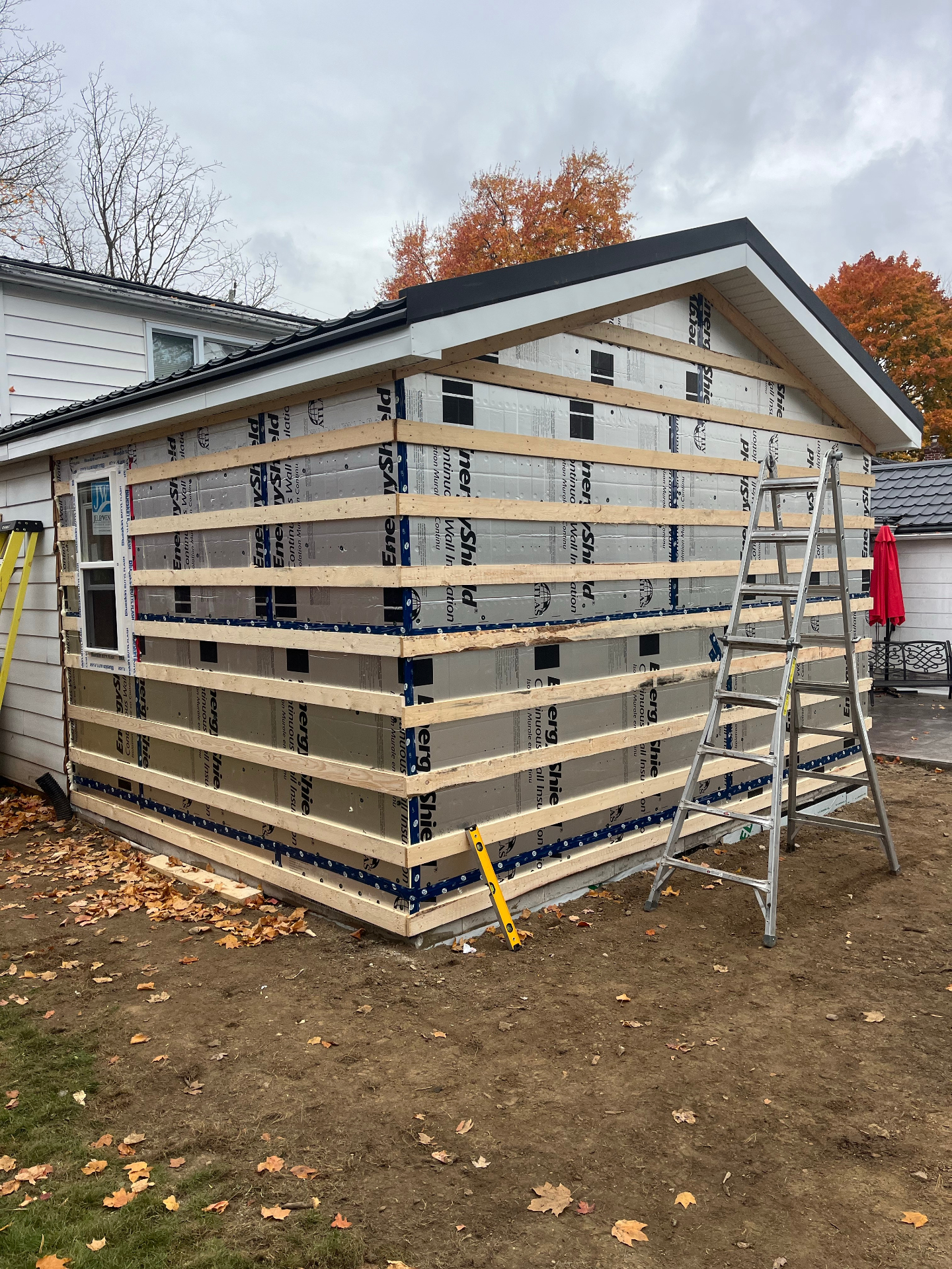 Exterior renovation addition in progress with insulated wall assembly and fresh roofline details