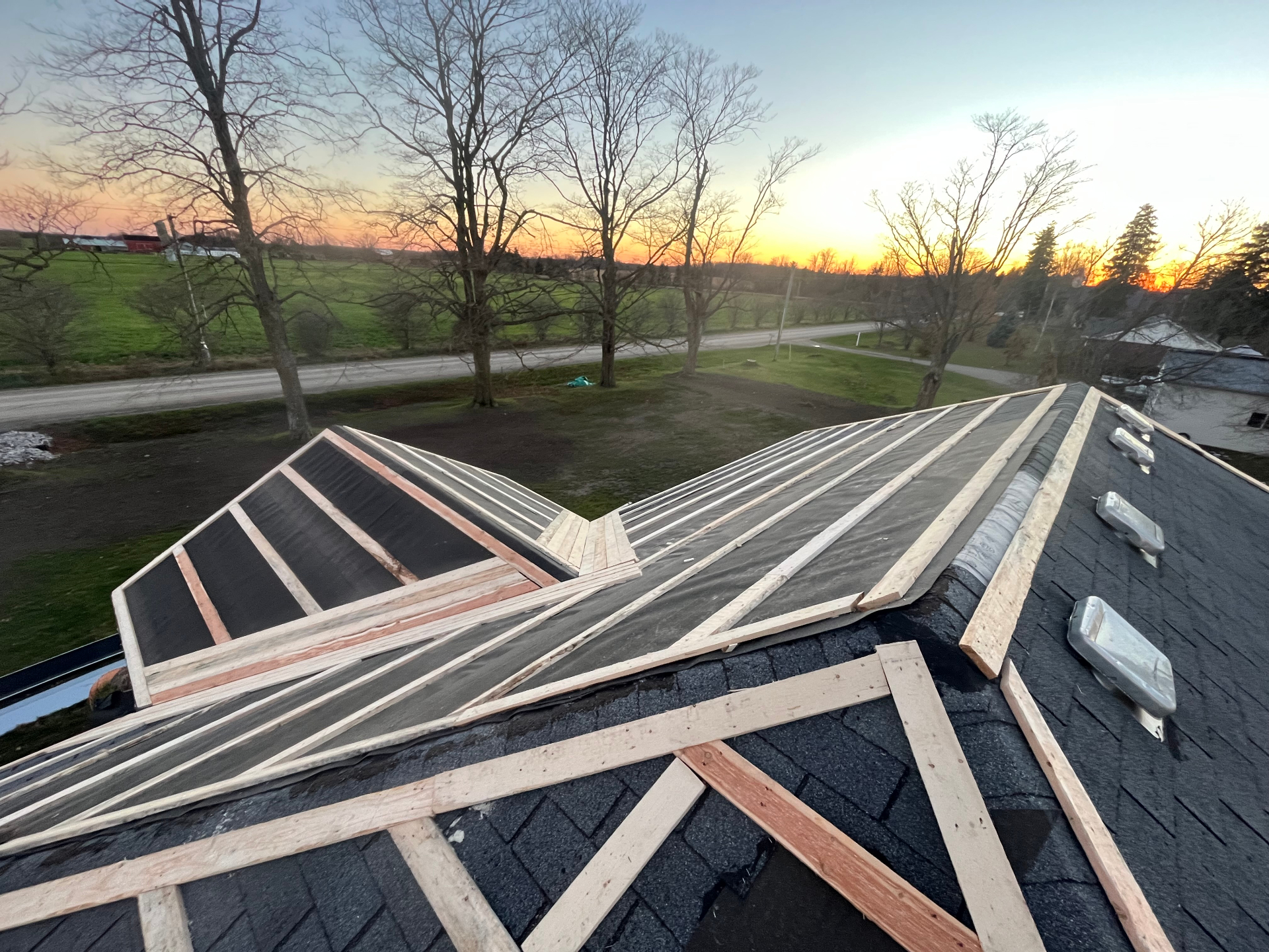 Roof framing and strapping layout at sunset before new metal roofing installation