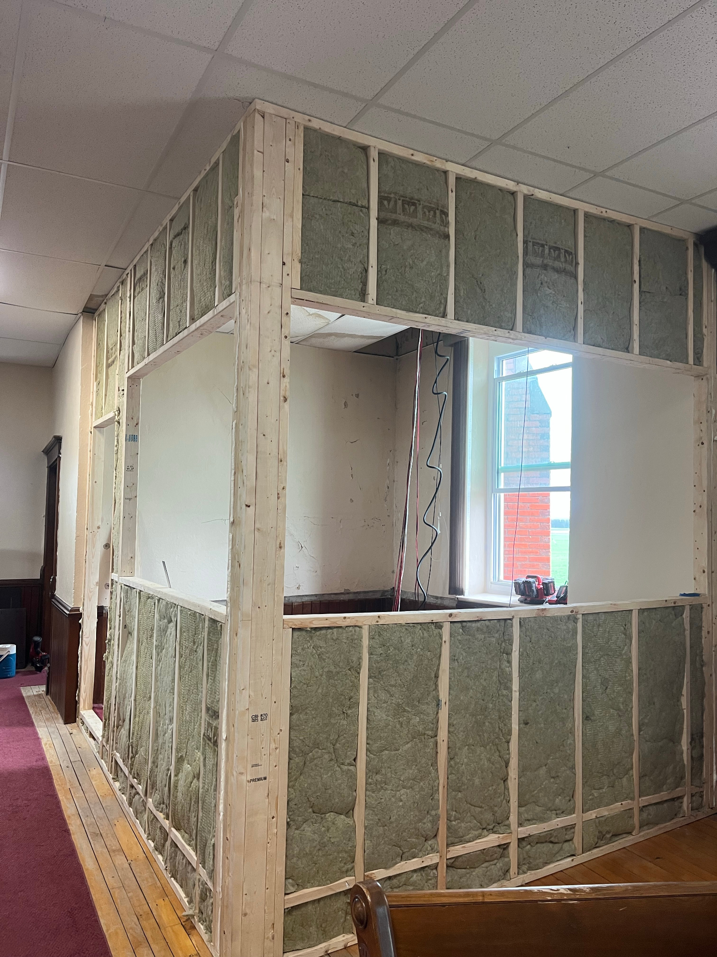 Freshly installed interior framing and ceiling repair work in progress inside a community hall