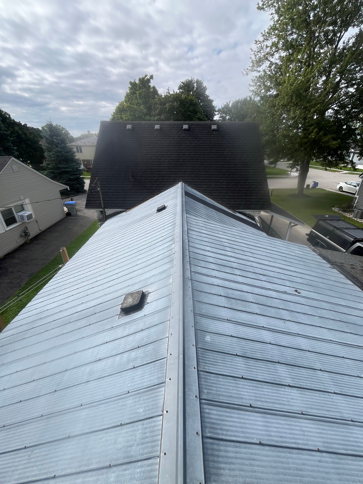 Aged galvanized standing seam metal roof on a residential home awaiting replacement