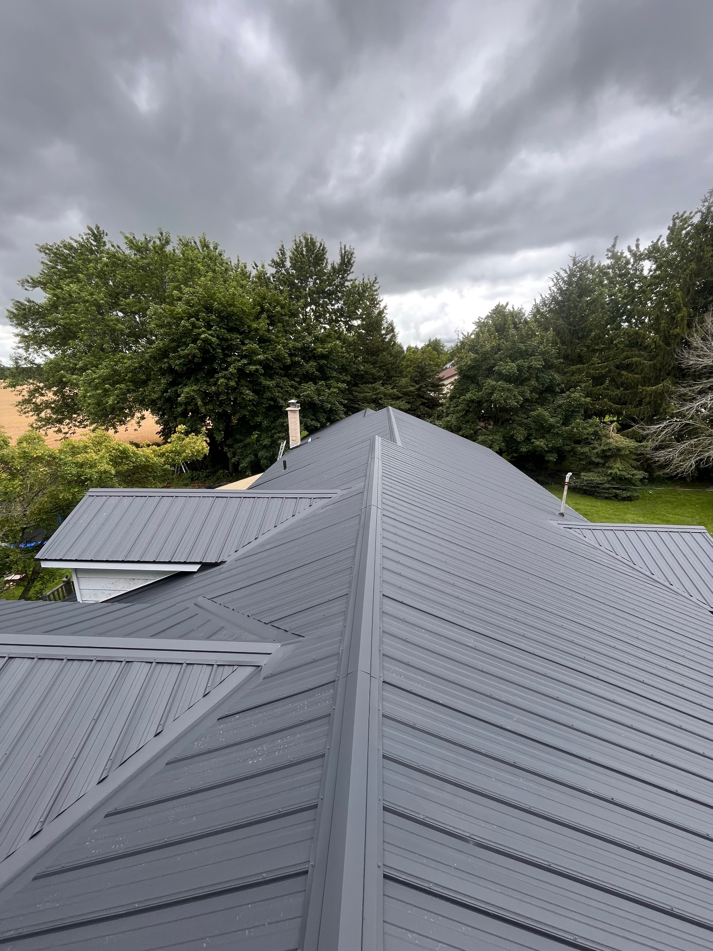 Finished charcoal grey standing seam metal roof on a rural Huron County home
